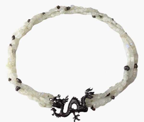 A white necklace with black dragon on it.