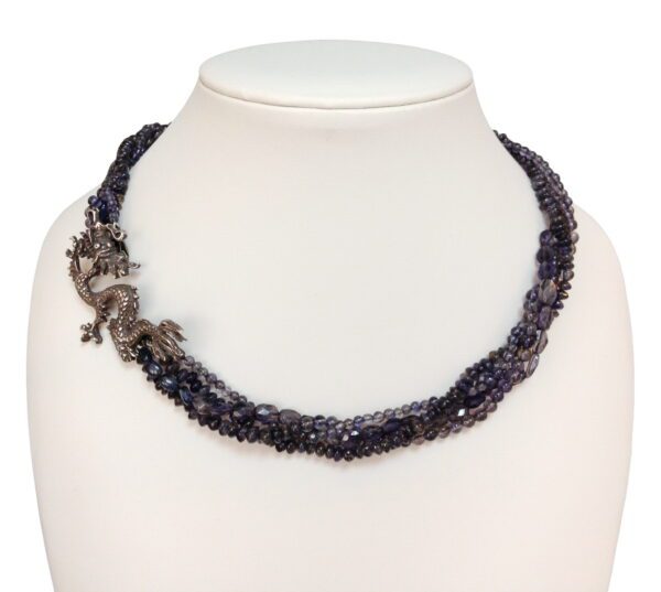 A necklace with a lizard on it and some purple beads