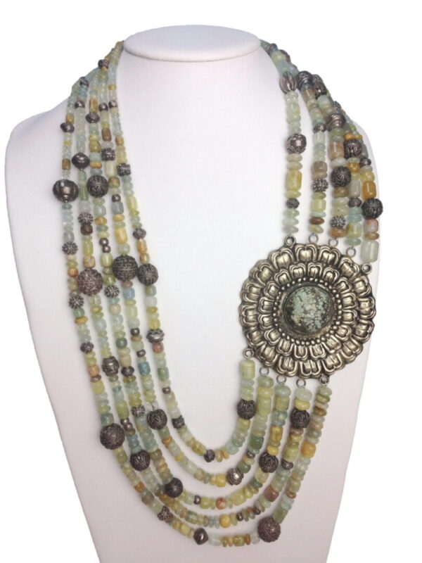 A necklace with many beads and a large brooch