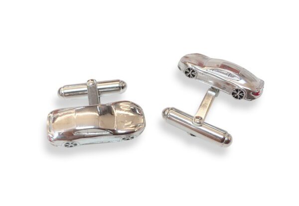 A pair of cufflinks with a car on them.