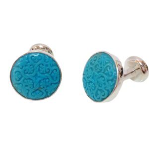 A pair of blue cufflinks with a pattern on them.