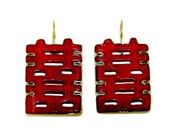 A pair of red earrings with gold colored wires.