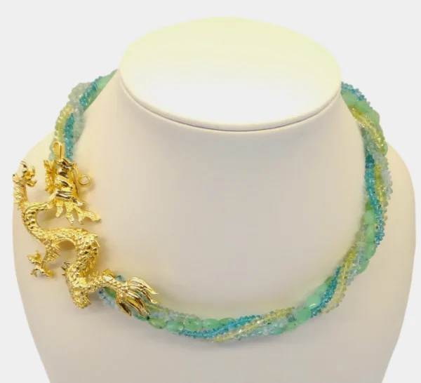 A necklace with gold and green beads on it.