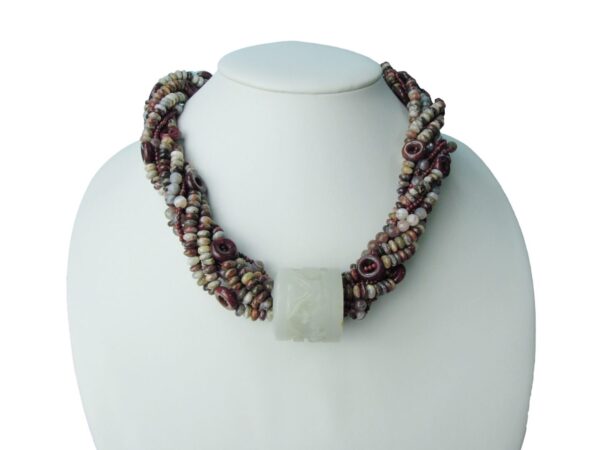 A necklace with multiple strands of beads and a square stone.