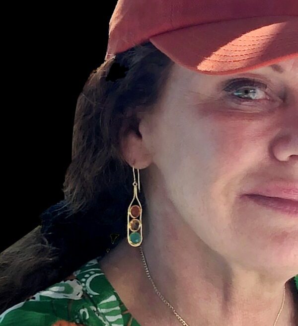 A woman wearing a hat and earrings.