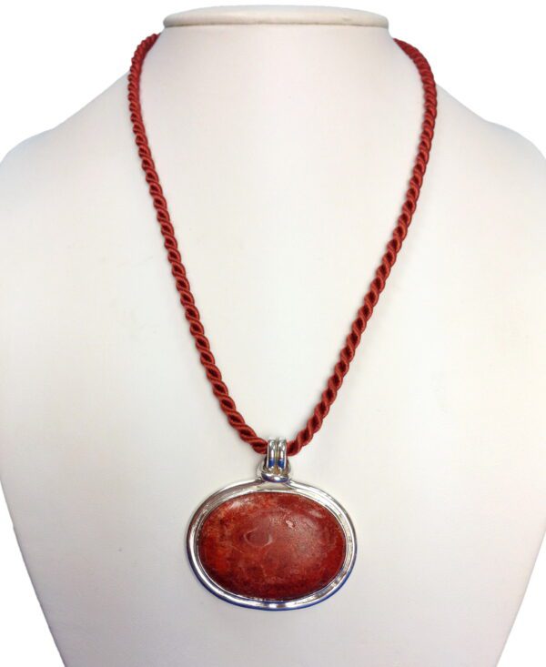 A necklace with a large red stone on it