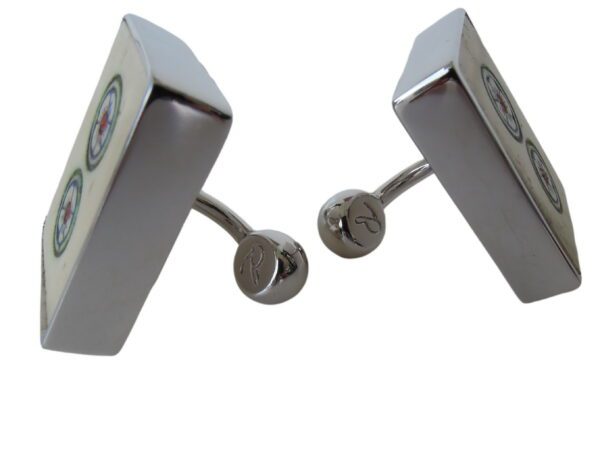 A pair of silver cufflinks with a clock on each side.