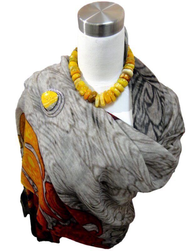 A woman wearing an elephant scarf with yellow beads.