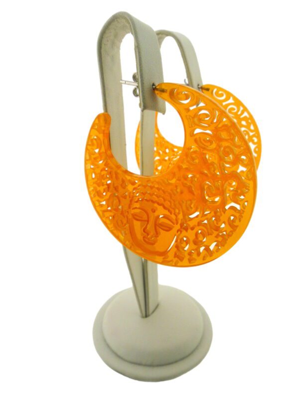 Large orange filigree Buddha resin earring with a Buddha face design, displayed on a white stand against a neutral background.