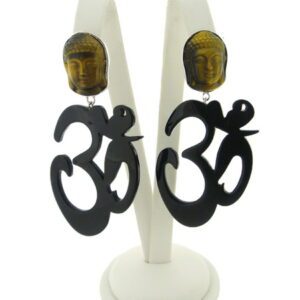 A pair of OM Resin Earrings featuring black "Om" symbols and Buddha face studs displayed on a white stand.