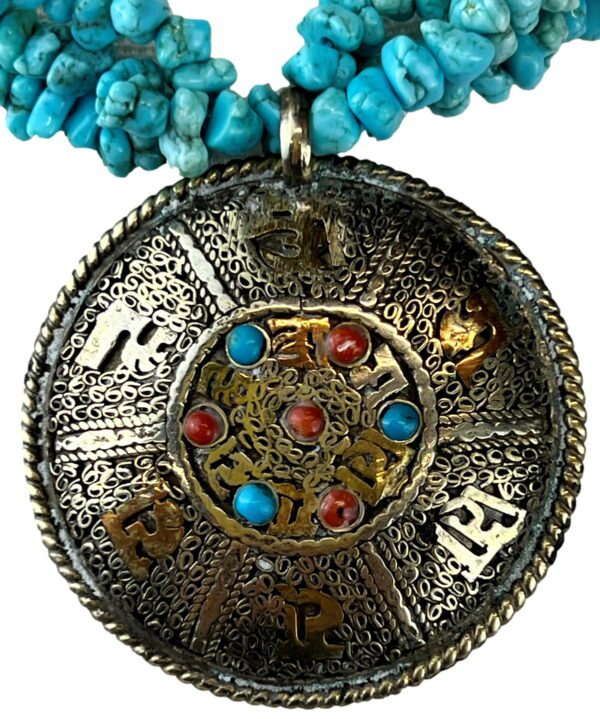 A close up of the necklace with a round pendant