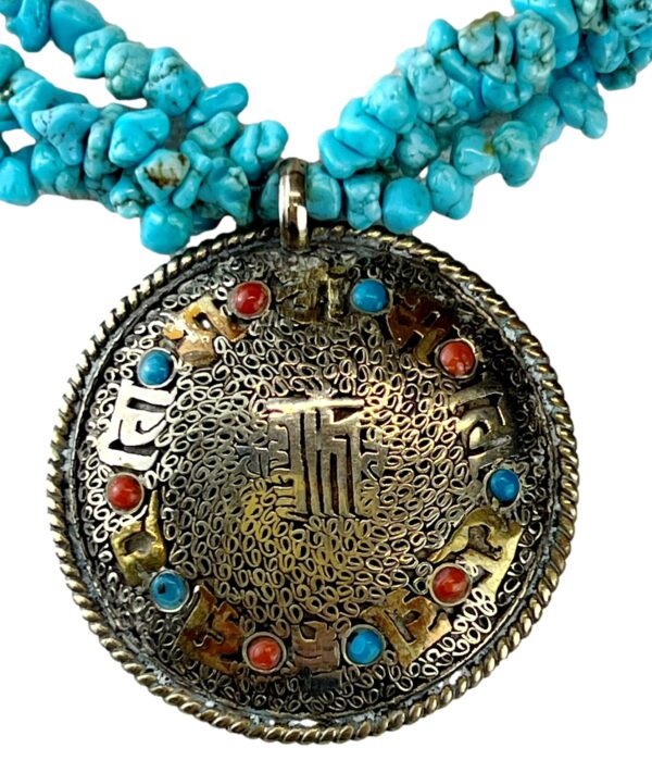 A close up of a necklace with turquoise and gold