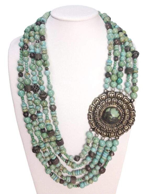 A necklace with many beads and a large pendant.