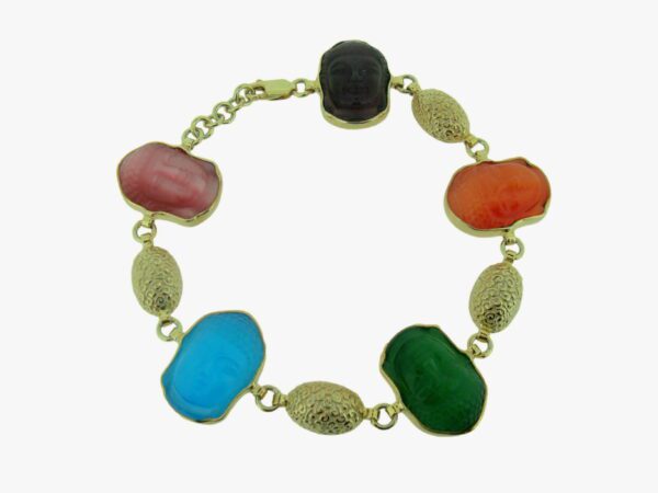 A gold bracelet with different colored stones on it.