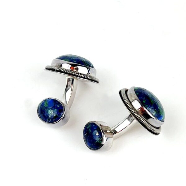 A pair of blue cufflinks with silver rim and lapis lazuli.