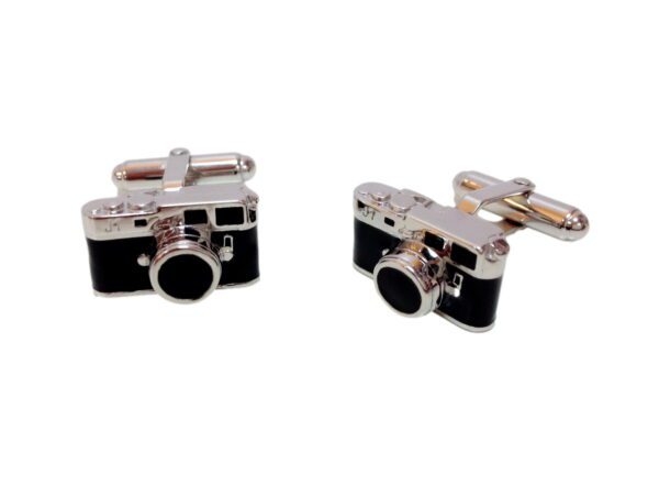 A pair of cufflinks with a camera on them.