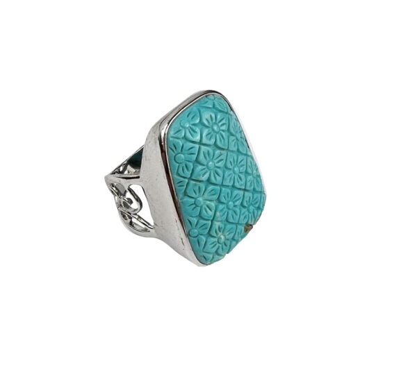 A silver ring with a turquoise stone on it's side.