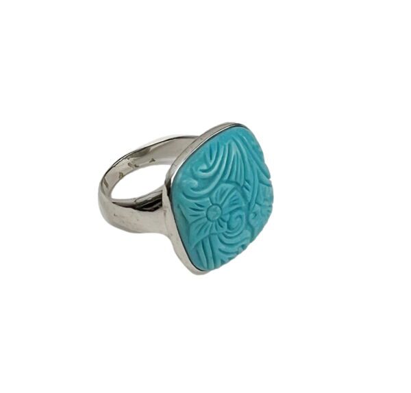 A silver ring with a blue stone on it's side.