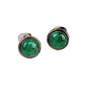 A pair of green earrings sitting on top of a white table.