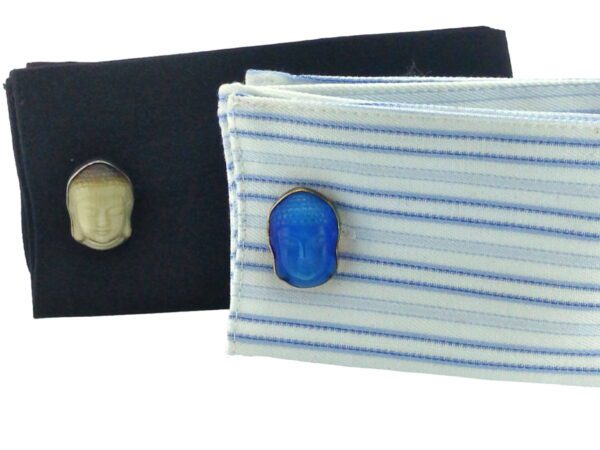 A pair of cufflinks on top of a black shirt.