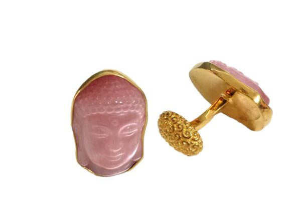 A pair of pink buddha cufflinks with gold trim.