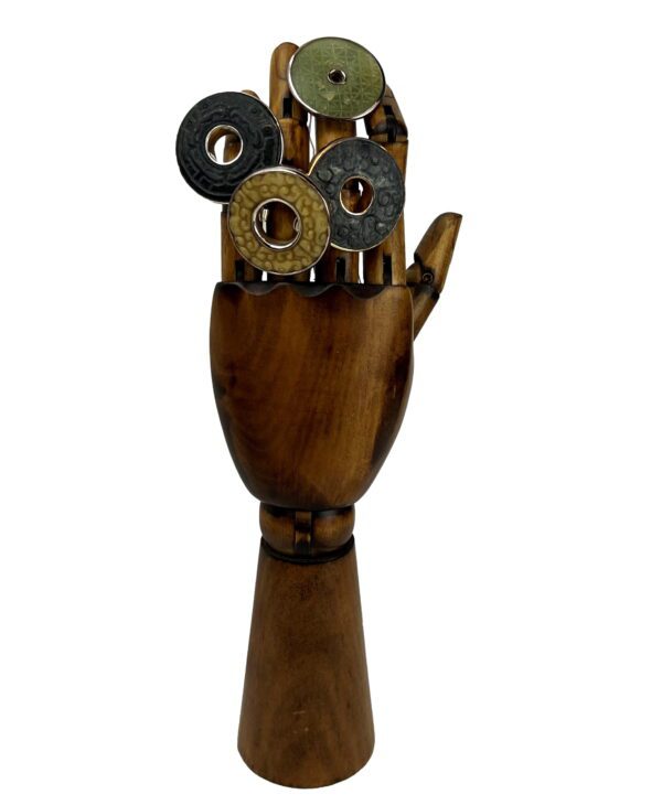 A wooden hand holding some metal objects