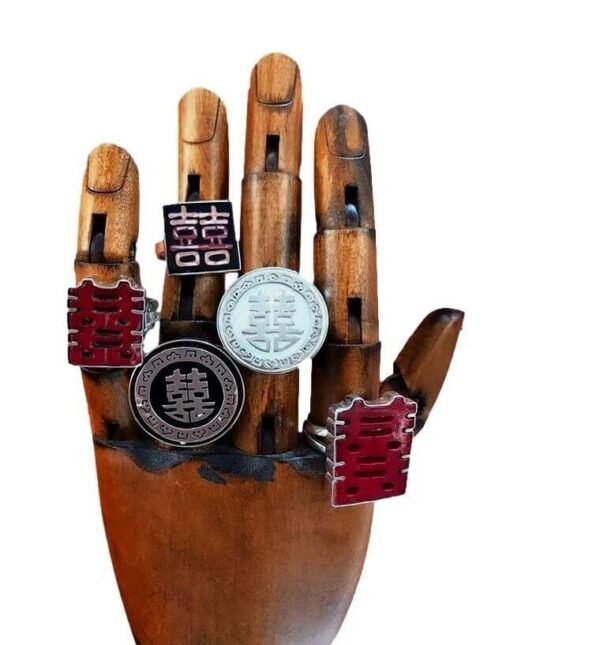 A wooden hand model displaying the Double Happiness MOP Ring with intricate designs, isolated against a white background.