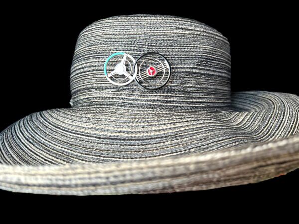 Gray striped wide-brimmed hat with Double Steering Wheel Brooch pins: one depicting a peace sign and another with a red heart symbol.