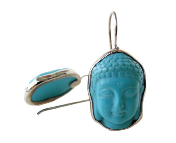 A pair of earrings with buddha head in the middle.