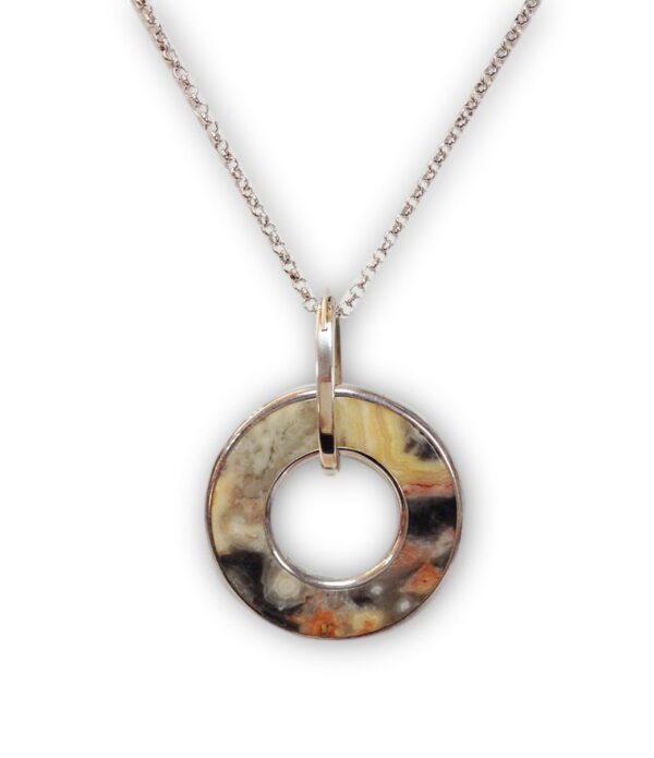 A Fancy Stone Donut Wrapped Pendant with multicolored stone inlay on a silver necklace, isolated on a white background.