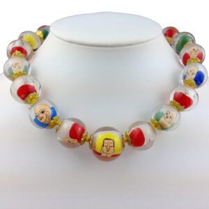 A necklace of glass beads with faces on them.