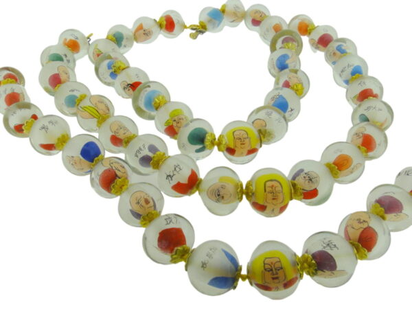 A long necklace of glass beads with cartoon characters.
