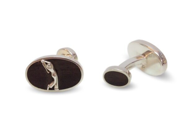 A pair of cufflinks with a black background and silver design.