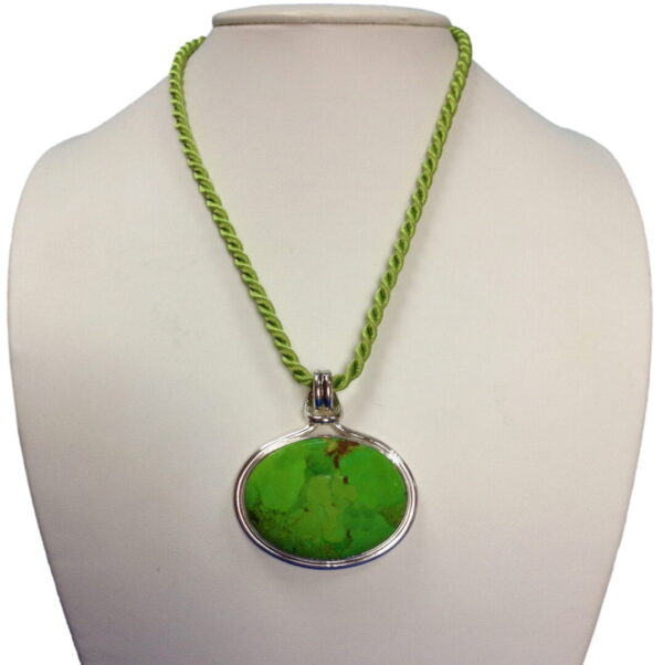 A green necklace with a large oval pendant.
