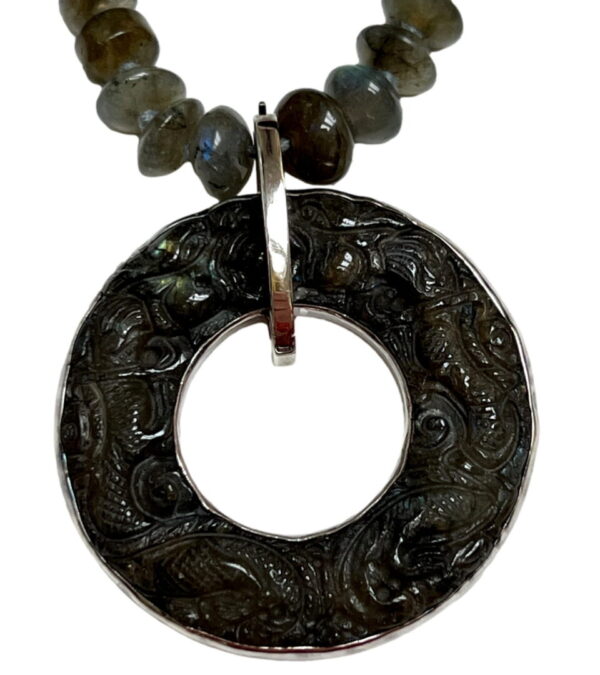 A necklace with an open circle and beads.