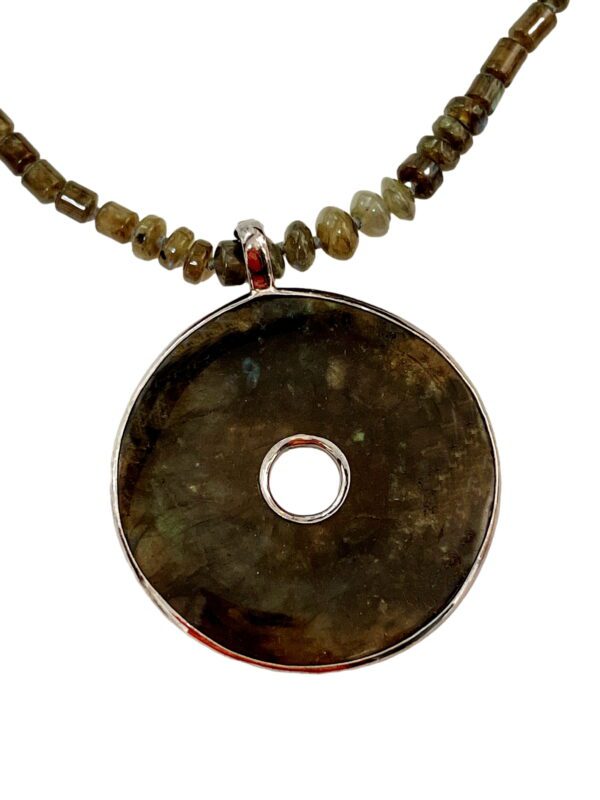 A necklace with a large round pendant and beads.