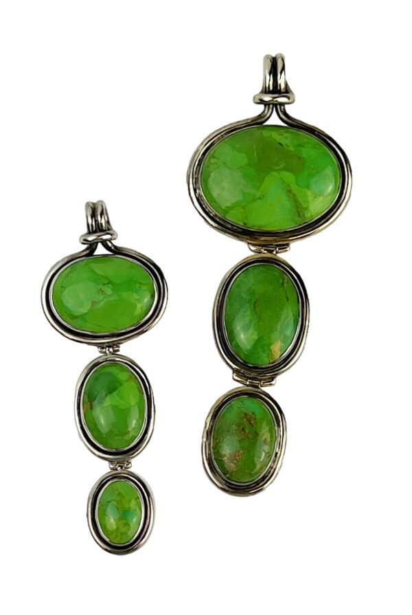 A pair of green glass pendants with silver frames.