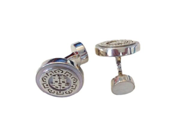 A pair of silver cufflinks with a round design.