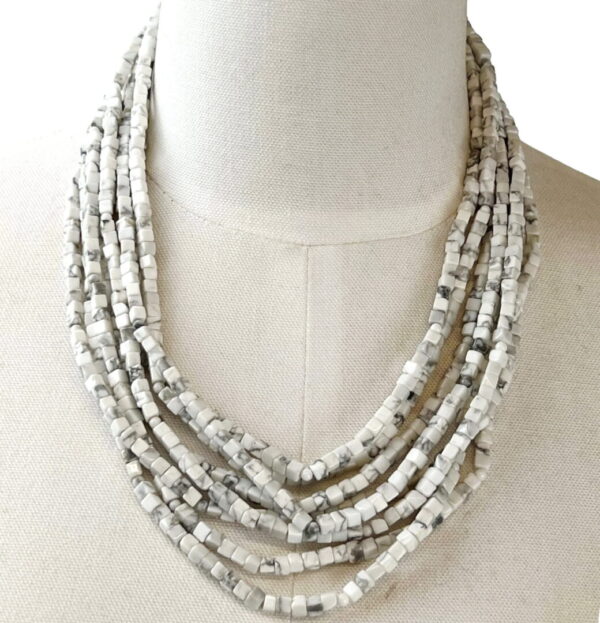 A necklace is shown on the bust of a woman.