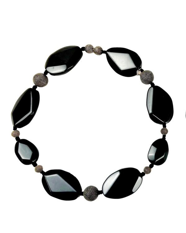 A black and gray necklace is in the middle of a circle.