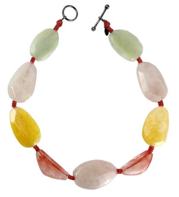 A necklace of various colored stones and red cord.