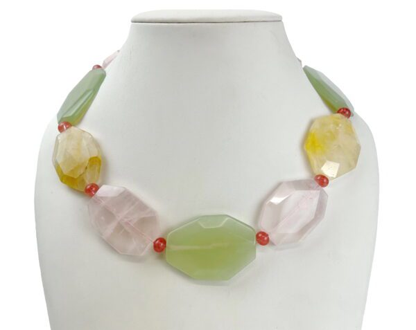 A necklace of different colored stones on a white background