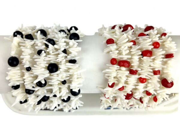 Two cakes with white frosting and red, black and white decorations.