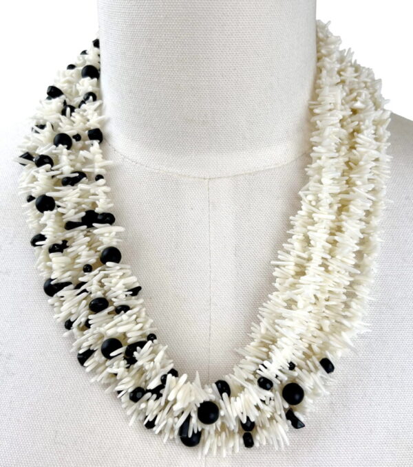 A necklace of white and black beads is shown.