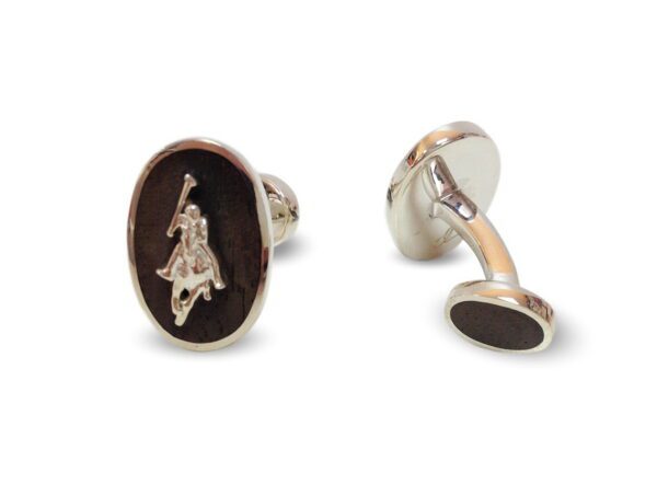 A pair of cufflinks with a horse and rider on them.