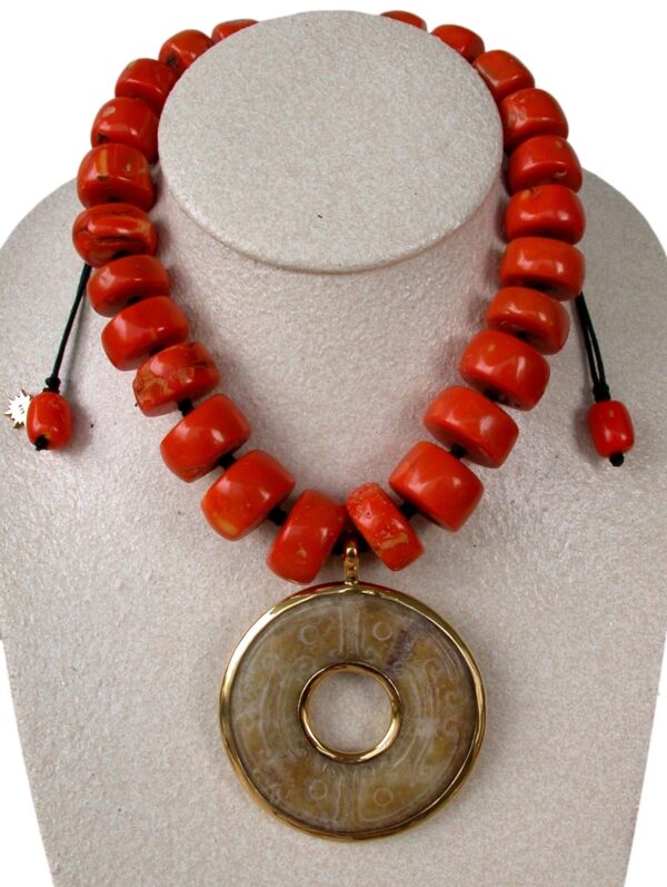 A vibrant red-orange beaded necklace with a Removable Jade Donut Pendant displayed on a white mannequin bust.