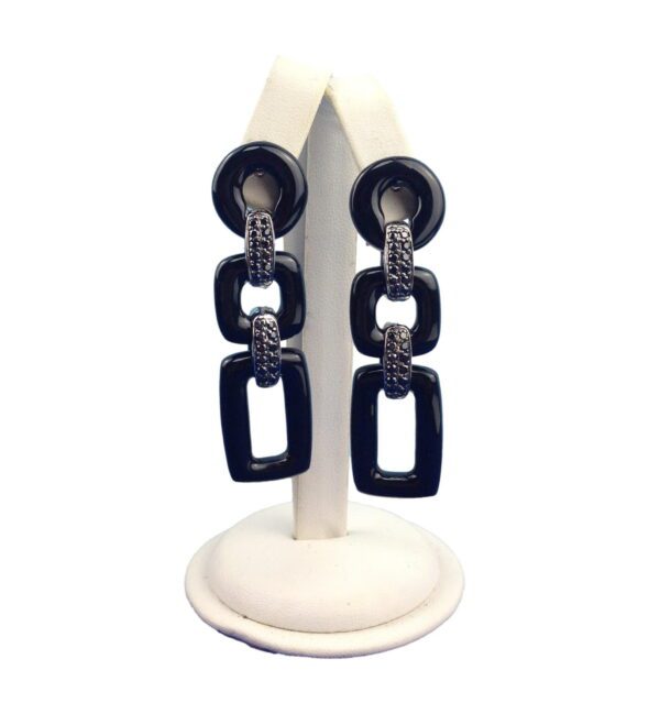 A display stand showcasing four pairs of Geometric 3 Tier Resin Earrings with rectangular and oval designs on a white background.