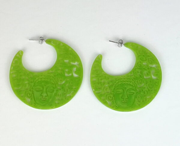 A pair of green earrings sitting on top of a table.