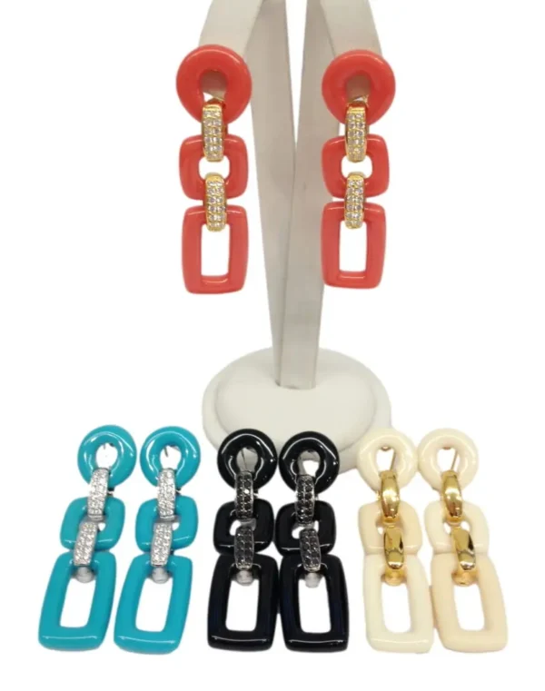 A display of different colored earrings on a white stand.