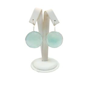 A pair of earrings on display in a white holder.